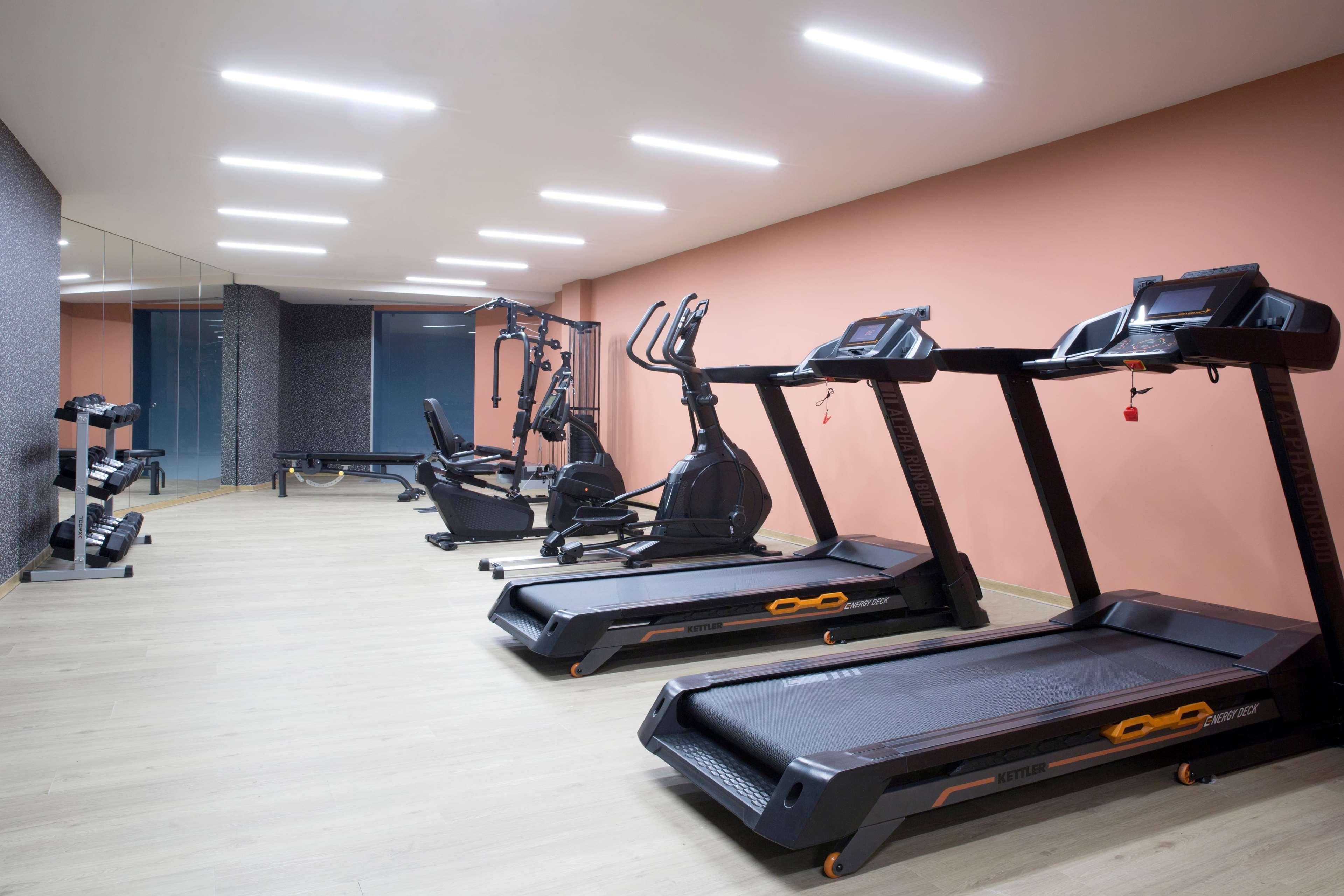 Dolce By Wyndham Athens Attica Riviera Hotel Vravrona Luaran gambar The photo shows a modern gym or fitness area featuring several exercise machines. There are two treadmills prominently displayed in the foreground, both equipped with a sleek design. In the background, there is an elliptical machine and a stationary 